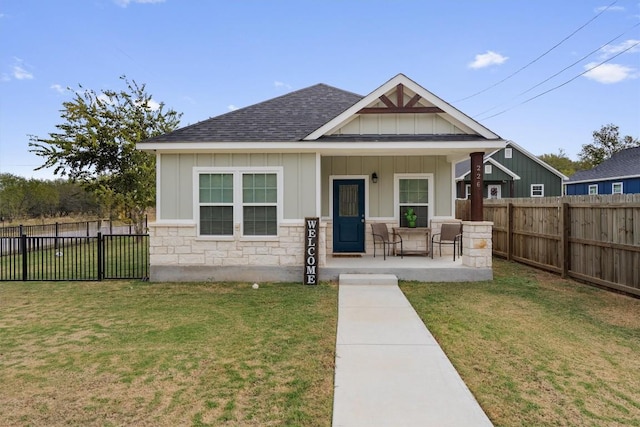 226 Spruce Ave, Luling, TX 78648 - view of front facade with board and batten siding, a porch, a shingled roof, and stone siding