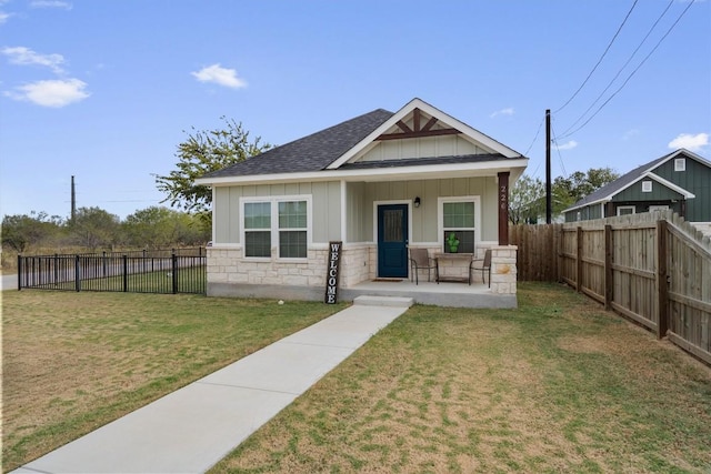 226 Spruce Ave, Luling, TX 78648 - view of front of property with board and batten siding, a shingled roof, a porch, and stone siding