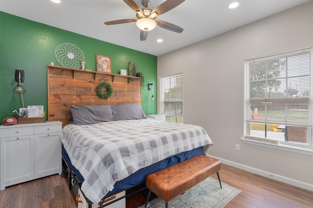 bedroom with ceiling fan, dark hardwood / wood-style flooring, and multiple windows