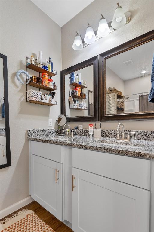 226 Spruce Ave, Luling, TX 78648 - full bath featuring double vanity, wood finished floors, and baseboards