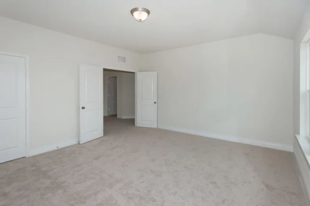 spare room featuring light colored carpet