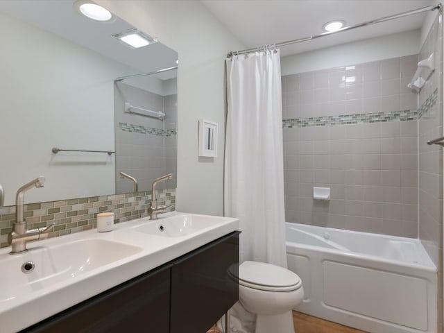 full bathroom featuring tasteful backsplash, vanity, shower / bath combo, and toilet