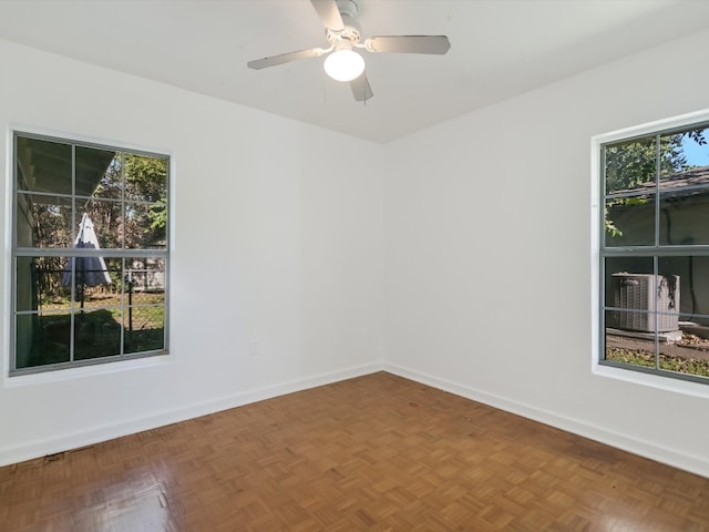 unfurnished room featuring ceiling fan, a healthy amount of sunlight, and parquet flooring