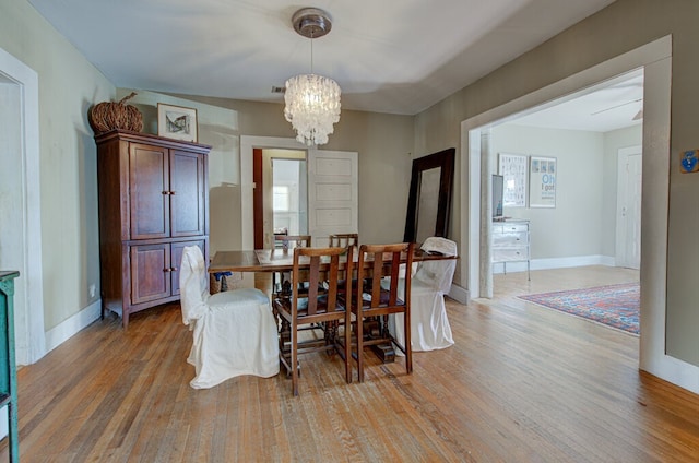 dining area with a chandelier and wood-type flooring