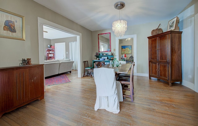 dining room with light hardwood / wood-style floors and a chandelier