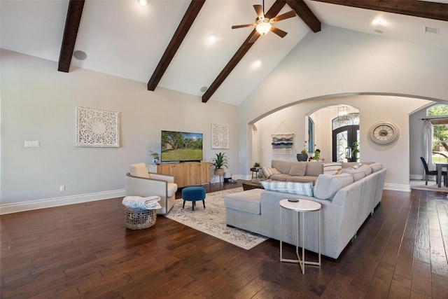 living area featuring hardwood / wood-style flooring, arched walkways, and high vaulted ceiling