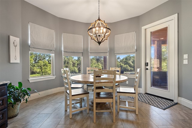 dining space featuring baseboards and a chandelier