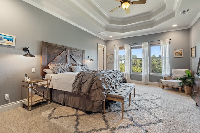 bedroom featuring carpet floors, visible vents, baseboards, a tray ceiling, and crown molding