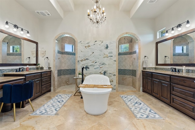 full bath with two vanities, visible vents, a walk in shower, and tile walls