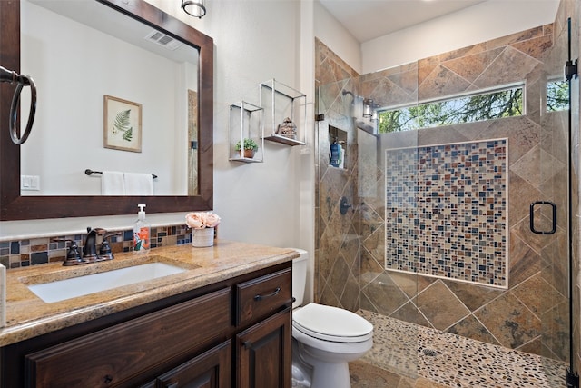 full bath with visible vents, a stall shower, vanity, and toilet