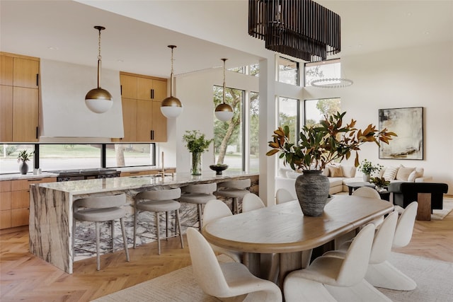 dining space featuring sink, light parquet flooring, and a high ceiling