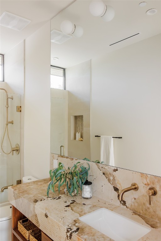 bathroom featuring vanity, an enclosed shower, and toilet