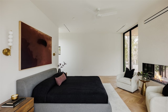 bedroom with floor to ceiling windows, light parquet flooring, and ceiling fan