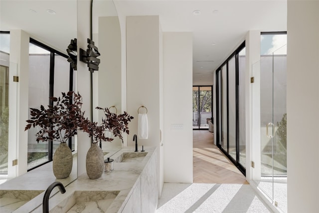 interior space featuring expansive windows, sink, and light parquet floors