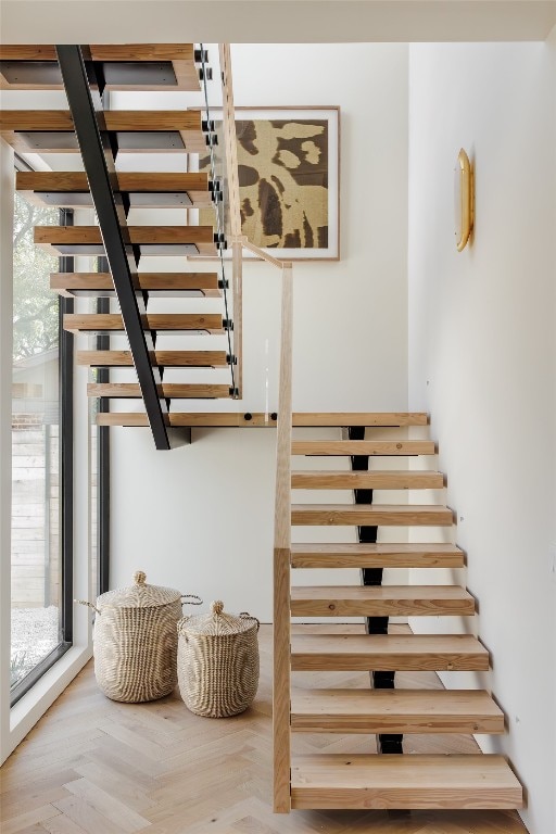 stairs featuring parquet flooring