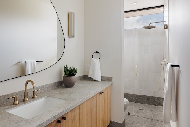 bathroom featuring vanity, toilet, and a tile shower