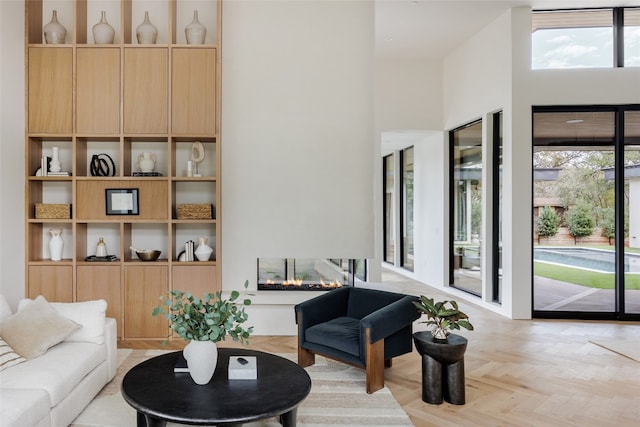 living room featuring a towering ceiling and light parquet floors