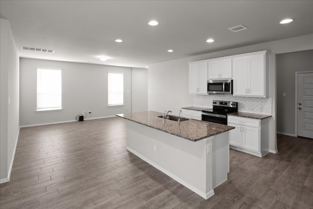 kitchen featuring white cabinetry, hardwood / wood-style floors, a kitchen island with sink, and appliances with stainless steel finishes