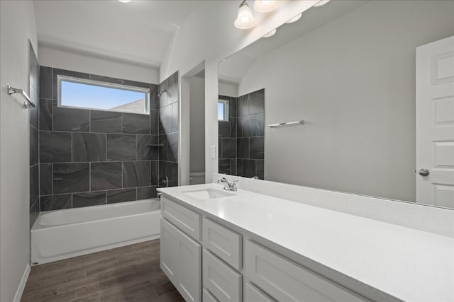 bathroom featuring tiled shower / bath combo, wood-type flooring, vanity, and lofted ceiling