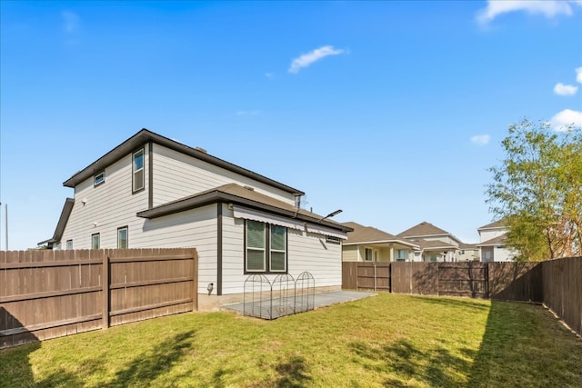 back of house featuring a lawn and a patio