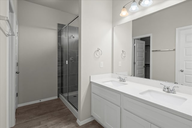 bathroom with wood-type flooring, vanity, and a shower with shower door