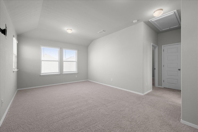 carpeted empty room featuring lofted ceiling