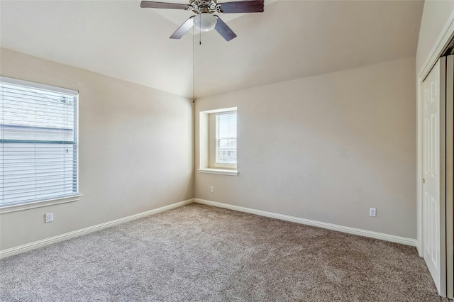 unfurnished room featuring ceiling fan, carpet floors, and vaulted ceiling