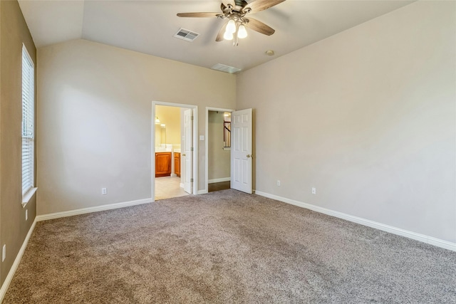 unfurnished bedroom featuring lofted ceiling, light colored carpet, ceiling fan, and connected bathroom