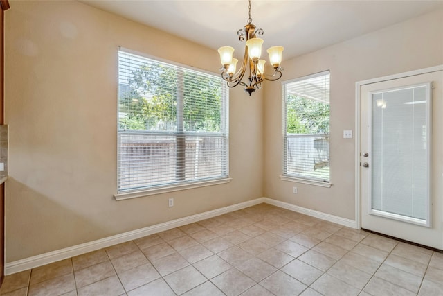 unfurnished dining area featuring light tile patterned floors, a chandelier, and a healthy amount of sunlight