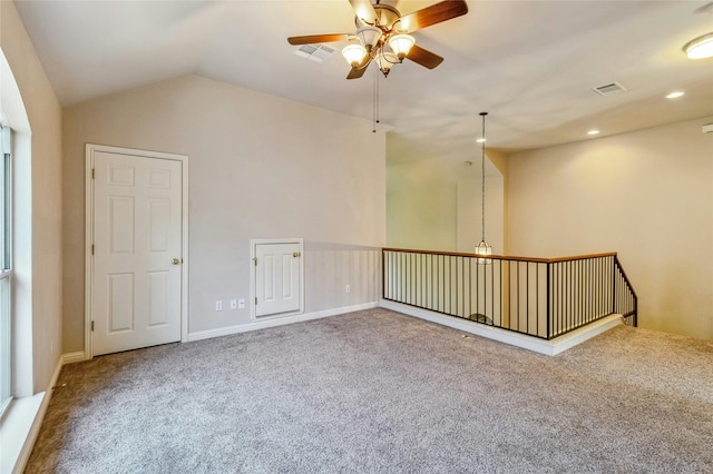 carpeted spare room with ceiling fan and vaulted ceiling