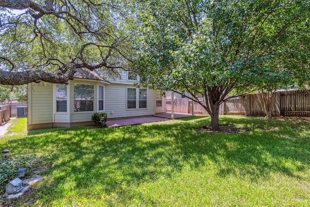 rear view of property featuring central air condition unit, a yard, and a patio area