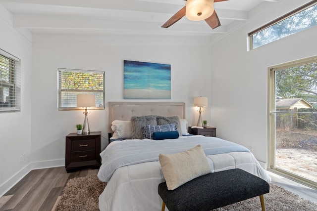 bedroom with multiple windows, ceiling fan, lofted ceiling with beams, and hardwood / wood-style flooring