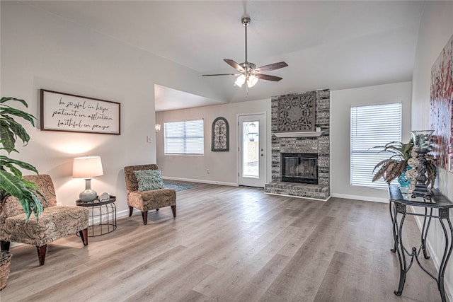 sitting room featuring wood-type flooring, a brick fireplace, ceiling fan, and lofted ceiling