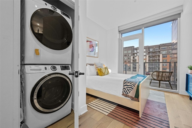 clothes washing area featuring stacked washer / dryer and light hardwood / wood-style floors