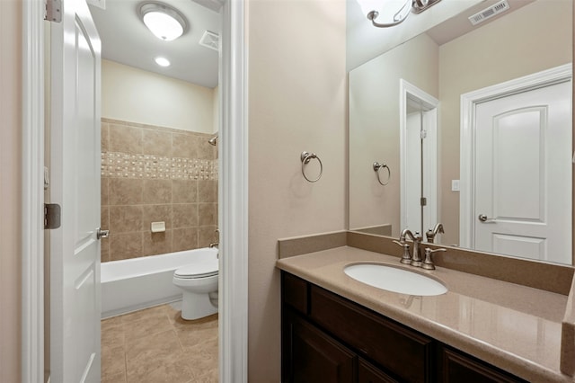 full bathroom featuring vanity, tiled shower / bath, tile patterned floors, and toilet