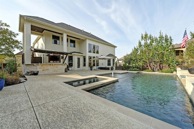 rear view of property featuring a patio, exterior bar, and a pool with hot tub