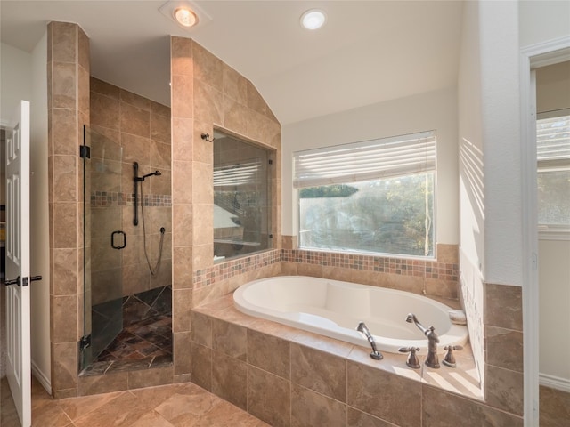 bathroom with separate shower and tub, plenty of natural light, and vaulted ceiling