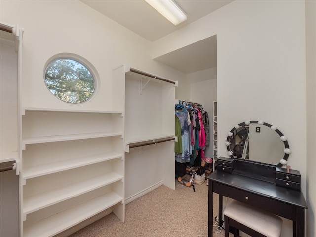 walk in closet with light carpet