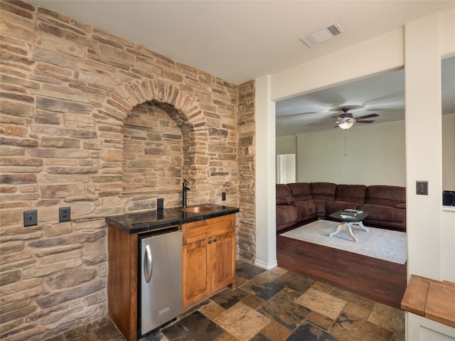 kitchen with ceiling fan, stainless steel fridge, sink, and dark wood-type flooring