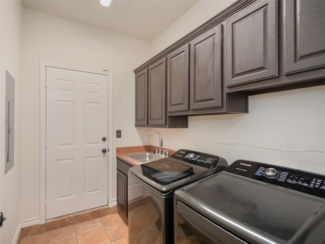 laundry room featuring cabinets, light tile patterned floors, washing machine and dryer, and sink