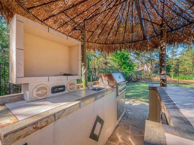 view of patio featuring sink, an outdoor kitchen, and a grill