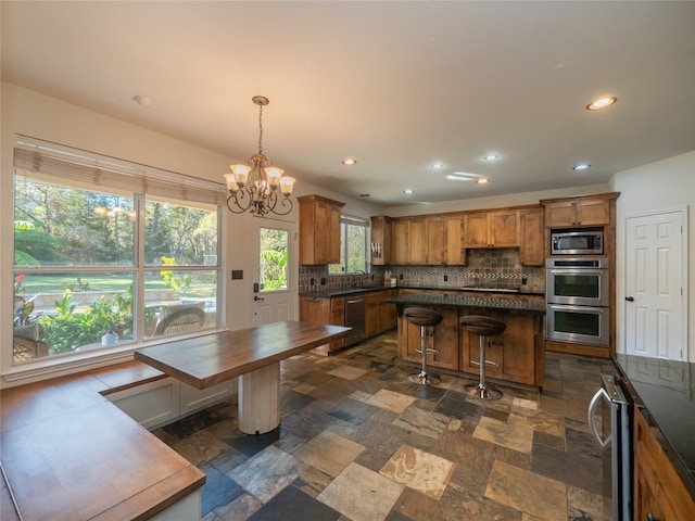 interior space featuring backsplash, hanging light fixtures, wine cooler, appliances with stainless steel finishes, and a notable chandelier