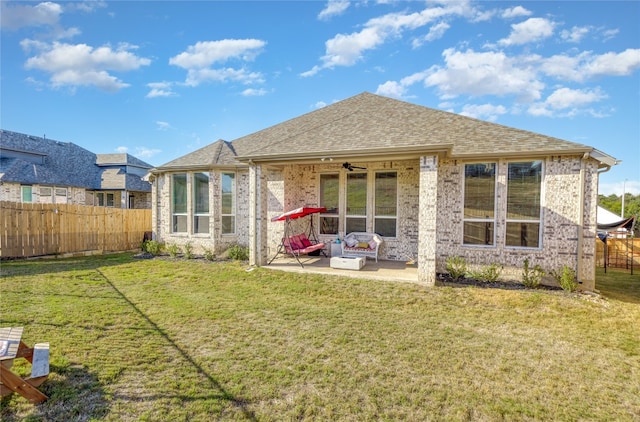 rear view of property featuring a lawn, ceiling fan, and a patio