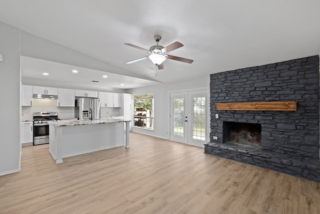 kitchen with a center island, light hardwood / wood-style flooring, vaulted ceiling, appliances with stainless steel finishes, and white cabinetry