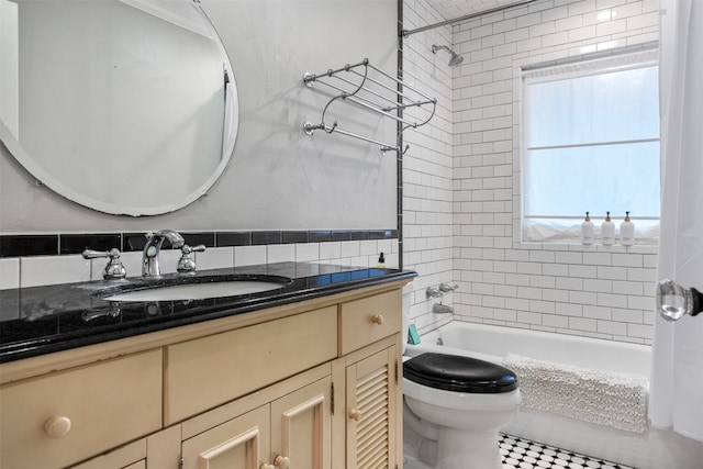 full bathroom with tile patterned floors, vanity, tile walls, toilet, and tiled shower / bath