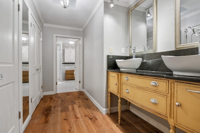 bathroom featuring vanity, wood-type flooring, and crown molding