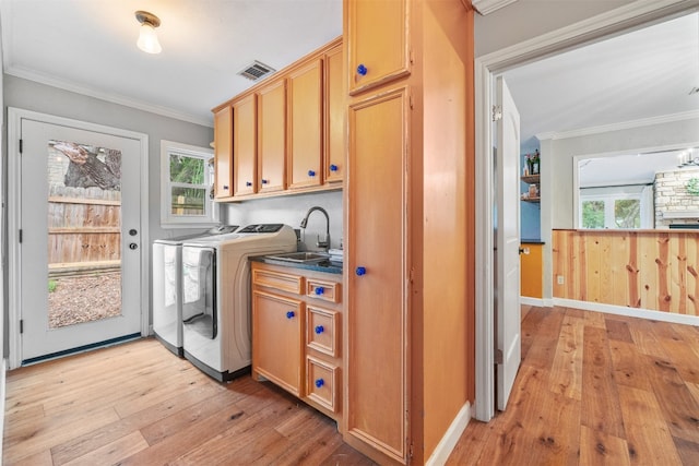 washroom with cabinets, crown molding, sink, light hardwood / wood-style flooring, and separate washer and dryer