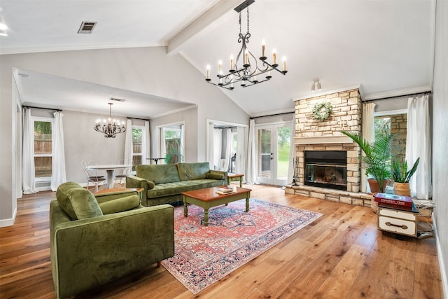 living room featuring a stone fireplace, a chandelier, hardwood / wood-style floors, and lofted ceiling with beams