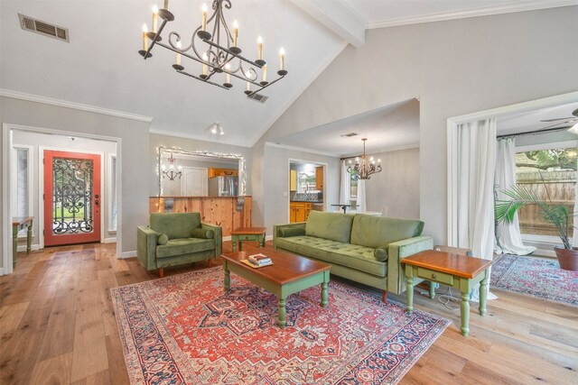 living room with light wood-type flooring, ceiling fan with notable chandelier, crown molding, beam ceiling, and high vaulted ceiling