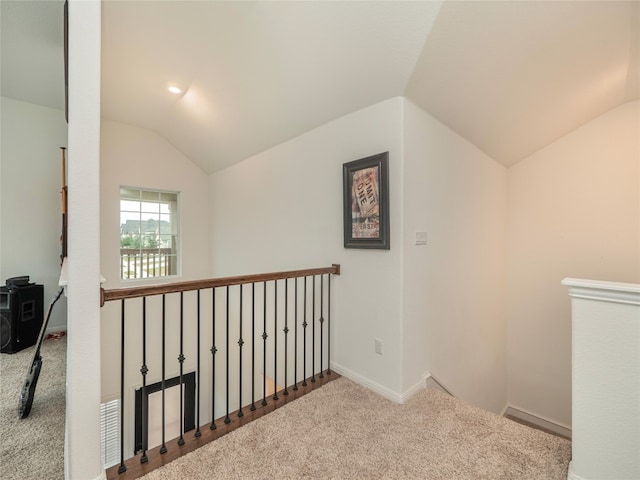 corridor featuring carpet floors and vaulted ceiling